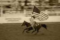 old image of a cowgirl on a horse with a flag