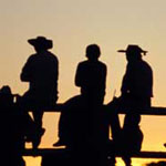 image of cowboys on a fence
